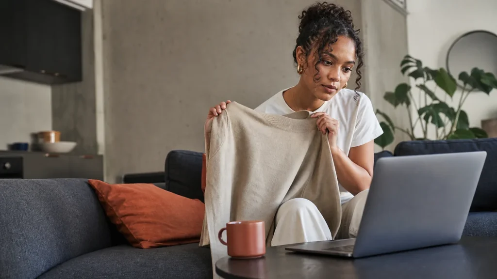 Woman comparing a neutral garment with information on a laptop