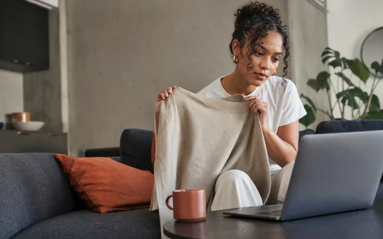 Woman comparing a neutral garment with information on a laptop